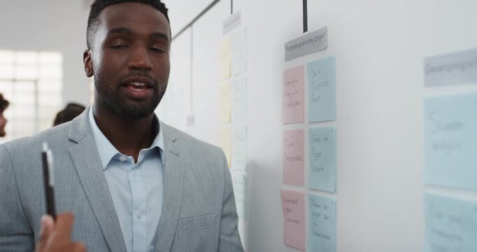 Man, talking and notes on whiteboard in office for training, planning and agenda for audit. People, meeting or discussion with storyboard for coaching, brainstorming and ideas for investment proposal