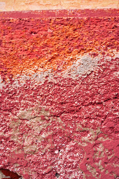 d&eacute;tail de texture sur un mur d&eacute;cr&eacute;pi de la fa&ccedil;ade d'une vielle maison en b&eacute;ton et briques rose