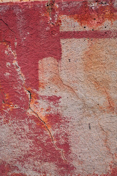 d&eacute;tail de texture sur un mur d&eacute;cr&eacute;pi de la fa&ccedil;ade d'une vielle maison en b&eacute;ton et briques rose