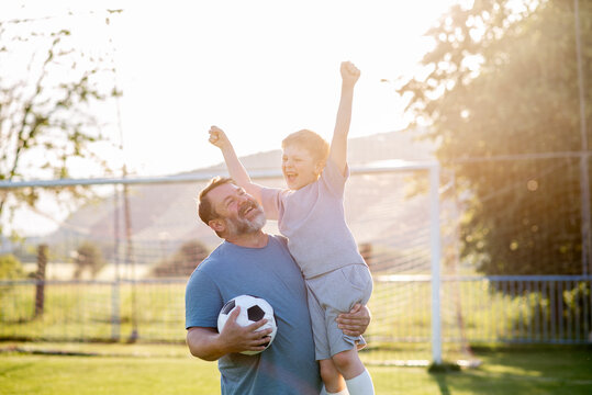 Dad and son sharing passion for football and active lifestyle.