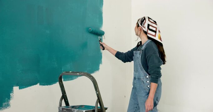 Back, painting and woman in home with wall, interior design and diy project for renovation. Painter, female person and paintbrush at house for remodeling, property makeover and household improvement