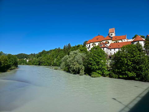 germany, magnificent old town and castle skyline above lech riverside framed by flourishing summer greenery