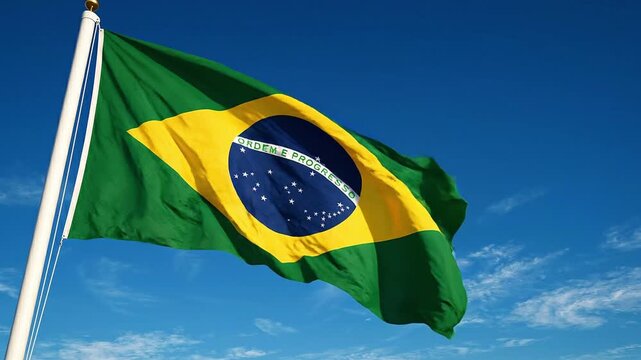 The brazilian flag waving in the wind against a blue sky with clouds, symbolizing national pride and identity