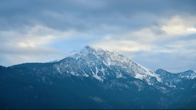 Epic misty mountain landscape with Olympos peak rising above a dense fog layer during a dramatic sunrise