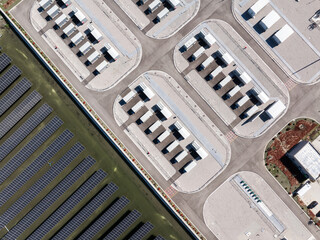 Obraz premium Aerial view of solar power plant and data center facilities with rows of photovoltaic panels