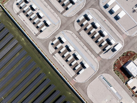 Aerial view of solar power plant and data center facilities with rows of photovoltaic panels