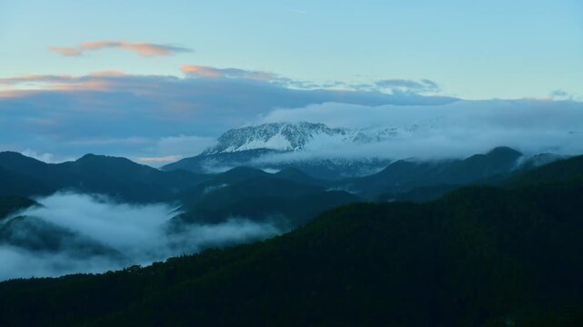 Epic mountain landscape timelapse with fast moving clouds over the peaks.