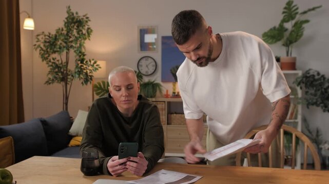 Angry man complaining to indifferent partner about bills
