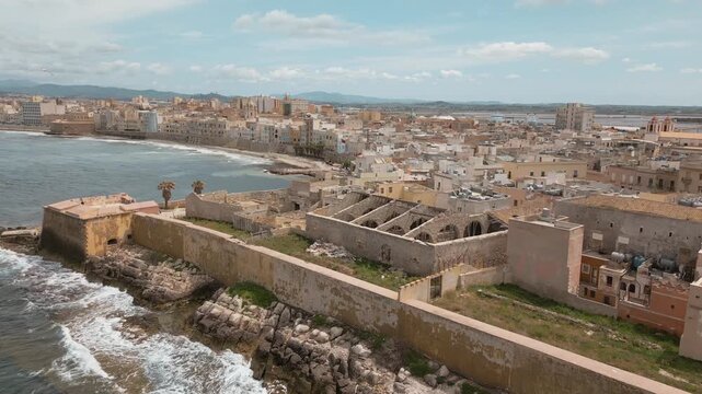 Trapani, Sicily - Mura di Tramontana and Bastion Fortifications and Ruins on Trapani's seashore, Aerial Close to Wide View of Old Town Cityscape and Bay with Seagulls Flying Above