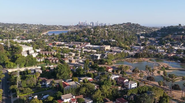 Scenic aerial of Silver Lake and downtown Los Angeles revealing residential hills, houses, Rowena Reservoir, under clear morning sunshine