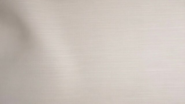 Gentle breeze caresses soft beige curtain creating subtle waves in calm interior setting