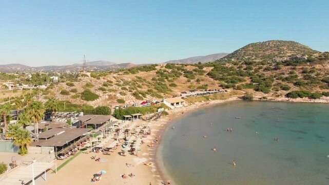Aerial view beach Paralia Lomvarda beach near Athens, Greece and seaside. Drone view from above. Sea and coast with sandy beach. Summer destination on the Mediterranean Sea, Europe
