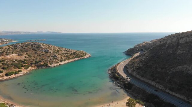 Aerial view of beach Paralia Lomvarda beach near Athens, Greece and seaside. Drone view from above. Sea and coast with sandy beach. Summer destination on the Mediterranean Sea, Europe
