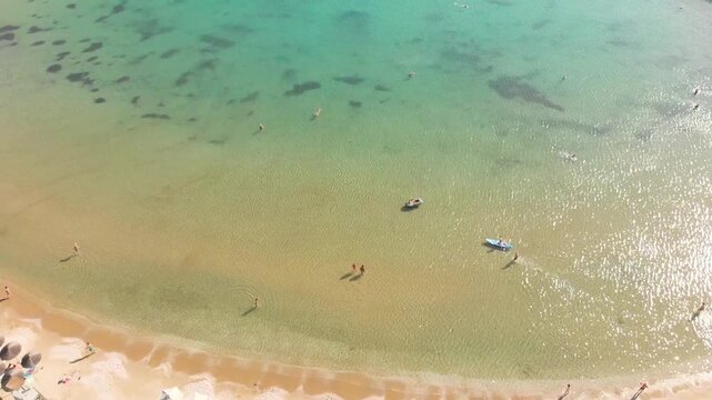 Aerial view of beach Paralia Lomvarda beach near Athens, Greece and seaside. Drone view from above. Sea and coast with sandy beach. Summer destination on the Mediterranean Sea, Europe
