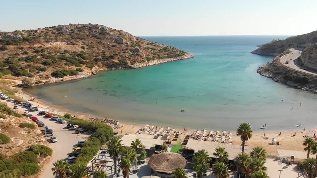 Aerial view of beach Paralia Lomvarda beach near Athens, Greece and seaside. Drone view from above. Sea and coast with sandy beach. Summer destination on the Mediterranean Sea, Europe
