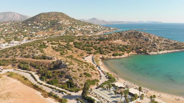Aerial view of  mountains near beach Paralia Lomvarda beach near Athens, Greece and seaside. Drone view from above. Sea and coast with sandy beach. Summer destination on the Mediterranean Sea, Europe

