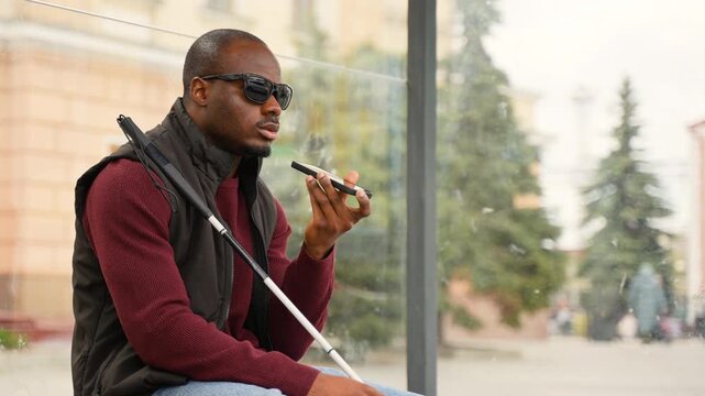 Blind African American man using smartphone with voice assistant