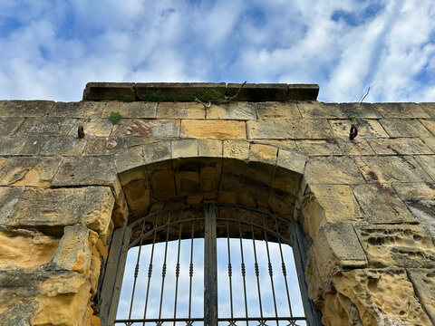 Stone Arch Gateway with Ornate Iron Gate at Ancient Coastal Fortress, La Galea, Basque Country