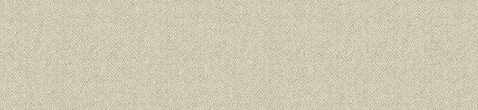 Detailed view of a beige herringbone fabric texture background with classic zig zag woven wool or linen material patterns.