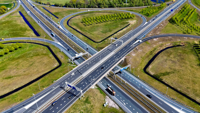 Aerial drone view road junction. Clover roundabout view from above. Car traffic on autobahn Netherlands.