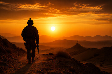 Obraz premium Soldier silhouette walking toward sunset over desert ridge