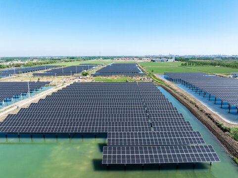 Aerial view of a floating solar power station with photovoltaic panel arrays on water surface