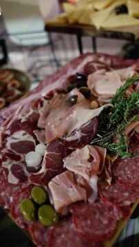 Close up of premium charcuterie board with prosciutto, ham, pancetta, bondiola, salami, longaniza, olives and almonds for elegant event catering