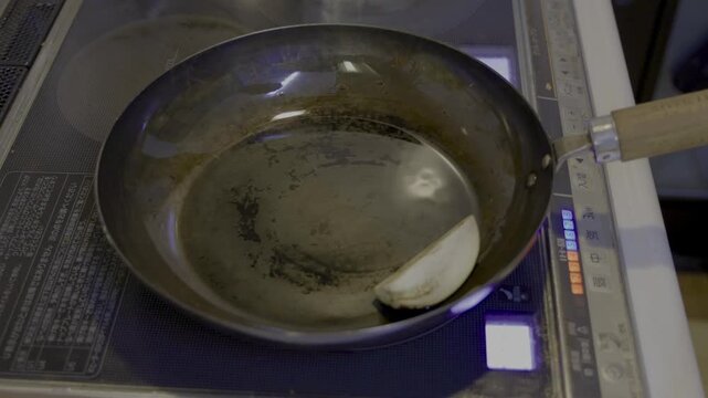 IHクッキングヒーターを使い鉄のフライパンで茄子を煮浸し用に焼き揚げるシーン