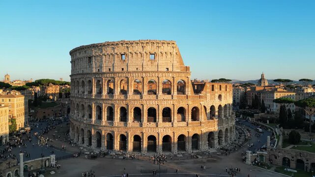 The colosseum in rome, italy, a large ancient stone amphitheater with arches and a blue sky background