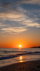 Fototapeta premium Beautiful colorful landscape with sunset on the calm sea vertical composition