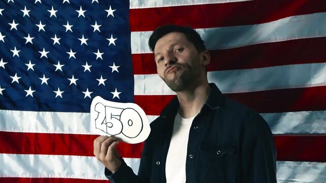 Caucasian man proudly stands in front of the American flag. He holds a sign with the number 250, symbolizing a quarter millennium