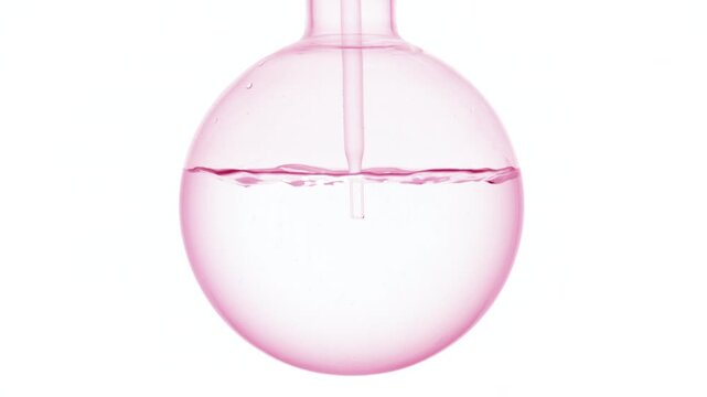 Full-frame close-up of pale delicate pink clear solution injected through a long dropper into a round-bottom flask, causing swirls and bubbles against plain white