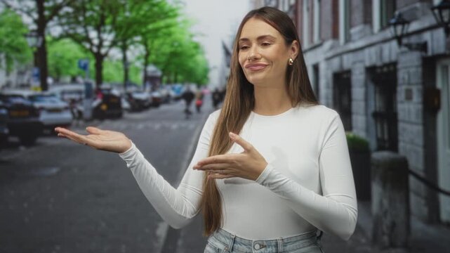 Woman presenting palm and gesturing with other hand on street with buildings and parked cars; bemusement uncertainty.