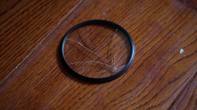 Handheld Shot of a cracked Camera Lens Filter on the ground