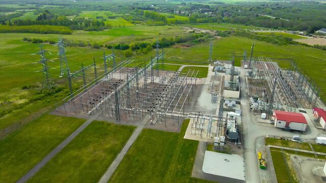 Aerial flight over a high voltage electricity substation. Industrial power lines and transformers distributing energy through the network
