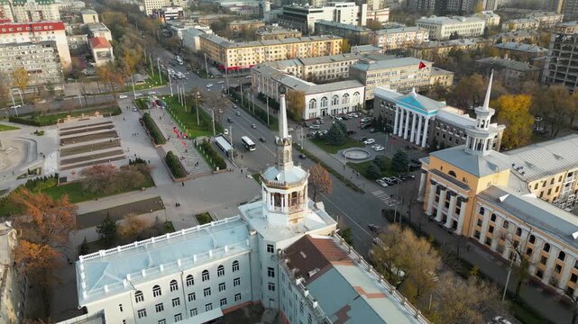 Soviet-era monumental architecture in Bishkek, Kyrgyzstan. Symmetrical educational buildings with classical columns and rotunda elements along a wide urban avenue.
