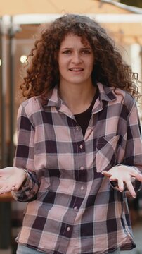 What. Why. Surprised frustrated pretty young woman raising hands asking reason of failure, demonstrating disbelief irritation by troubles outdoors. Confused lady walking in urban city sunshine street
