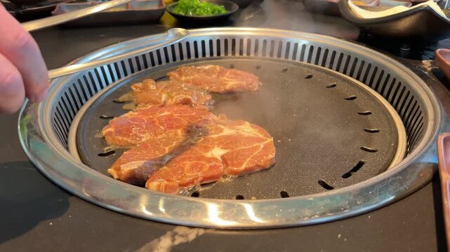 japanese Yakiniku grill barbecue preparation dinner, meat grilling on hot metal plate, Gourmet restaurant menu high quality meat presentation, Raw and cooking meat comparison on round barbecue grill