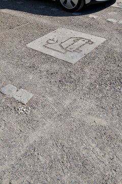 Minimalist electric vehicle charging station sign on gravel parking lot in Germany for eco friendly transport concept
