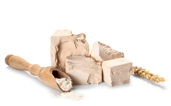 Fresh baker's yeast blocks with flour scoop and wheat ear, baking ingredients for bread and pastry making