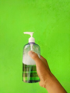 Hand holding bottle of clear hand sanitizer.
