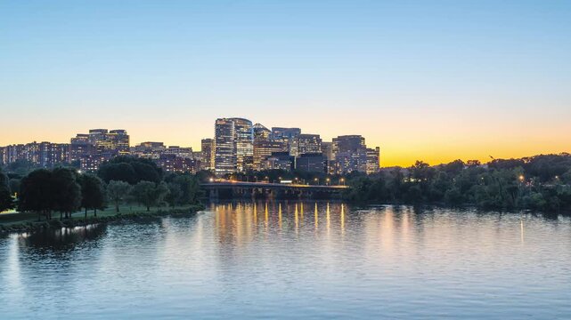 Arlington, Virginia, scenic static 4K timelapse video capturing the transitioning gradient sky over the illuminated Rosslyn skyline as office lights flicker and ripples move across the Potomac River a