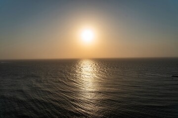 Obraz premium Sunset Over the Ocean With Bright Sun Reflecting on Water’s Surface During Evening Hours