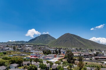 Mountains Rise Over a Small Town in Ecuador Under a Bright Blue Sky With a Few Clouds © Rodrigo