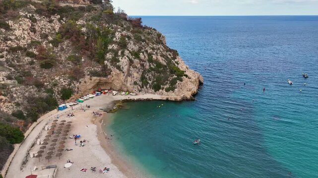 Cala Granadella beach fishing boats swimmers turquoise Javea aerial 4K