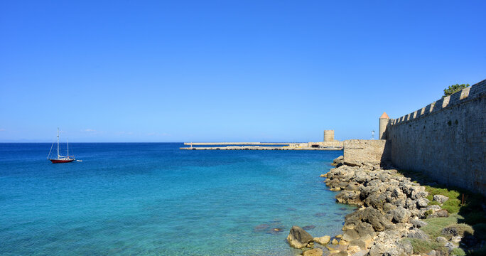Rhodes, Greece panorama view city wall and seashore with sail boat