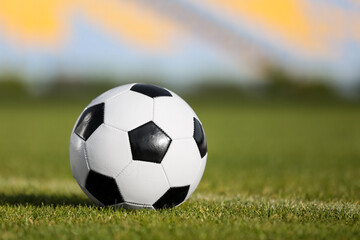 Fototapeta premium Soccer ball on green stadium grass, closeup
