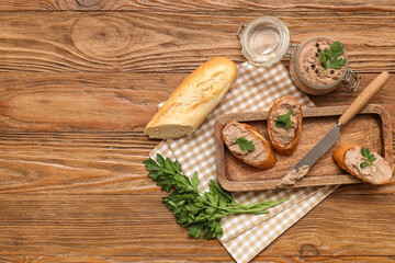 Naklejka premium Jar of tasty pate with toasts, parsley and knife on wooden background