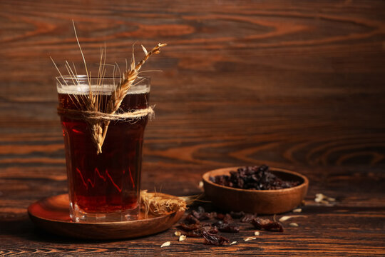 Glass of fresh kvass and wheat on wooden background