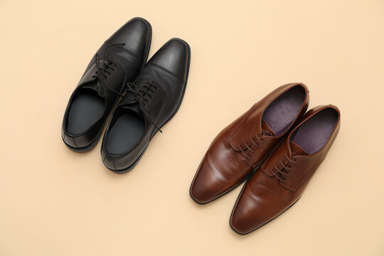 Different stylish male leather shoes on beige background